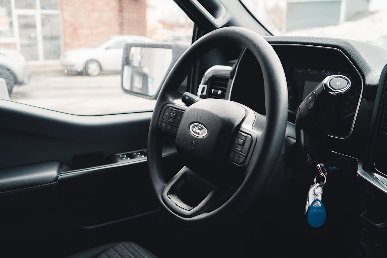 service-03 Interior view of a Ford vehicle showing steering wheel, dashboard, and car keys for modern automotive design.