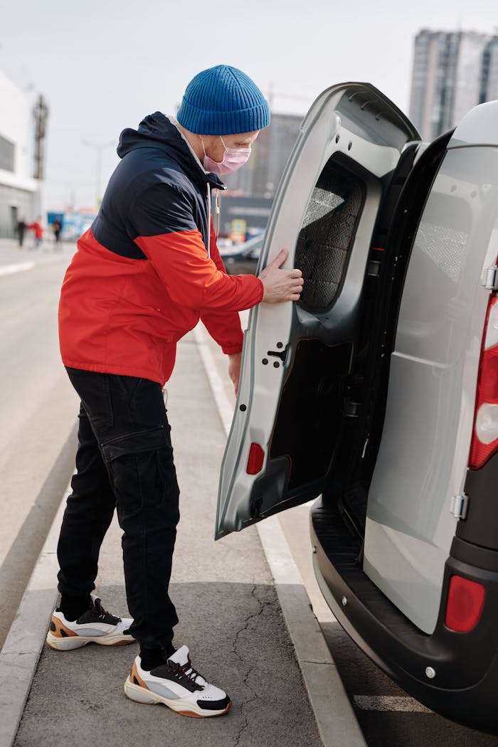 Mastering the First Impression: Your intriguing post title goes here A man wearing a face mask and beanie opens a van door on a city street.