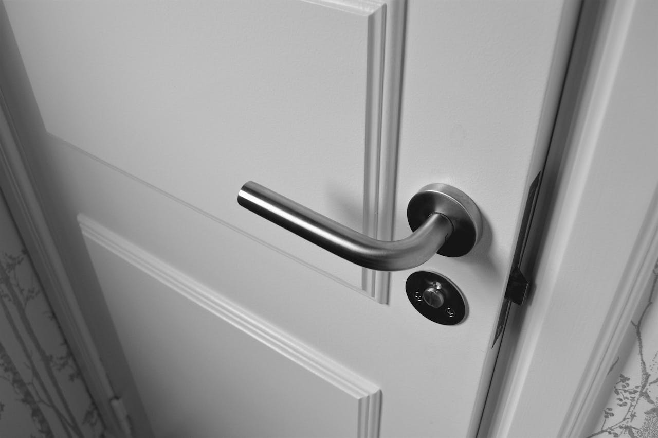 Crafting Captivating Headlines: Your awesome post title goes here Close-up of a sleek steel door handle on a white door, showcasing modern interior design in monochrome.